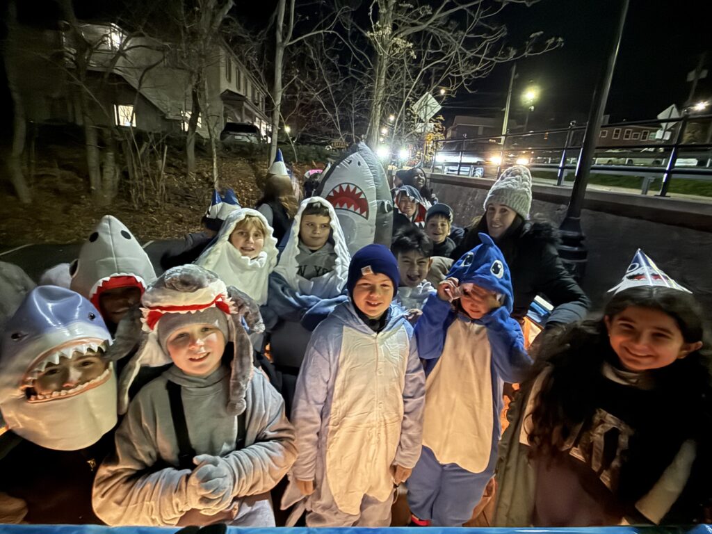 parade float with students dressed as sharks on it