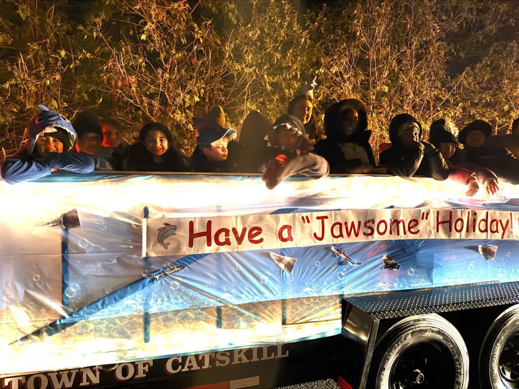 parade float with students dressed as sharks on it