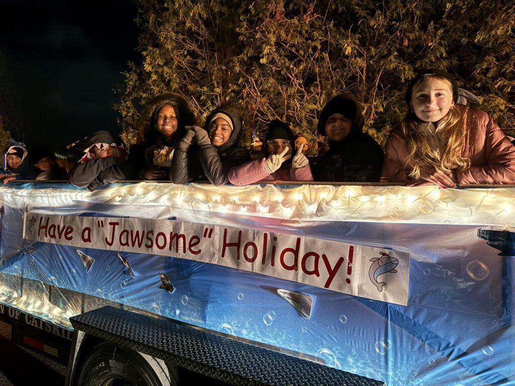 parade float with students dressed as sharks on it
