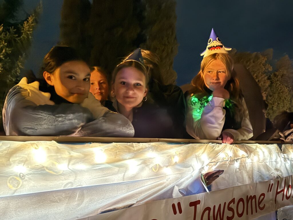parade float with students dressed as sharks on it