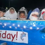 parade float with students dressed as sharks on it