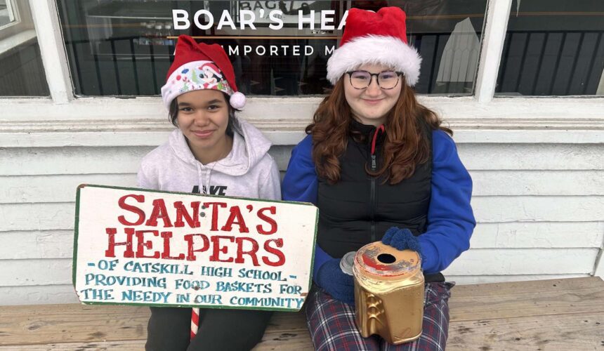 Santas Helpers 1 two girls in Santa hats holding Santa's helpers sign