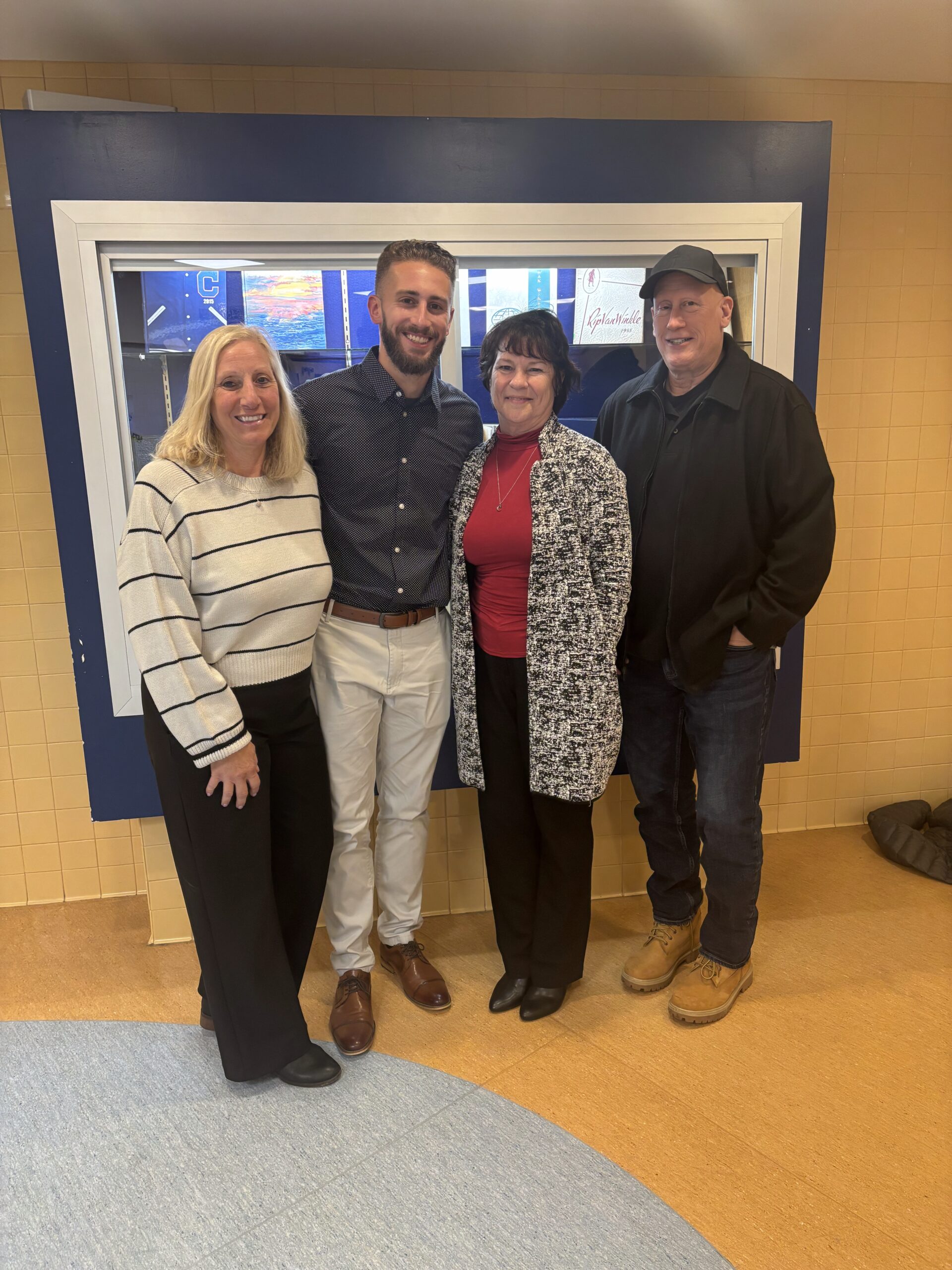 man poses with family