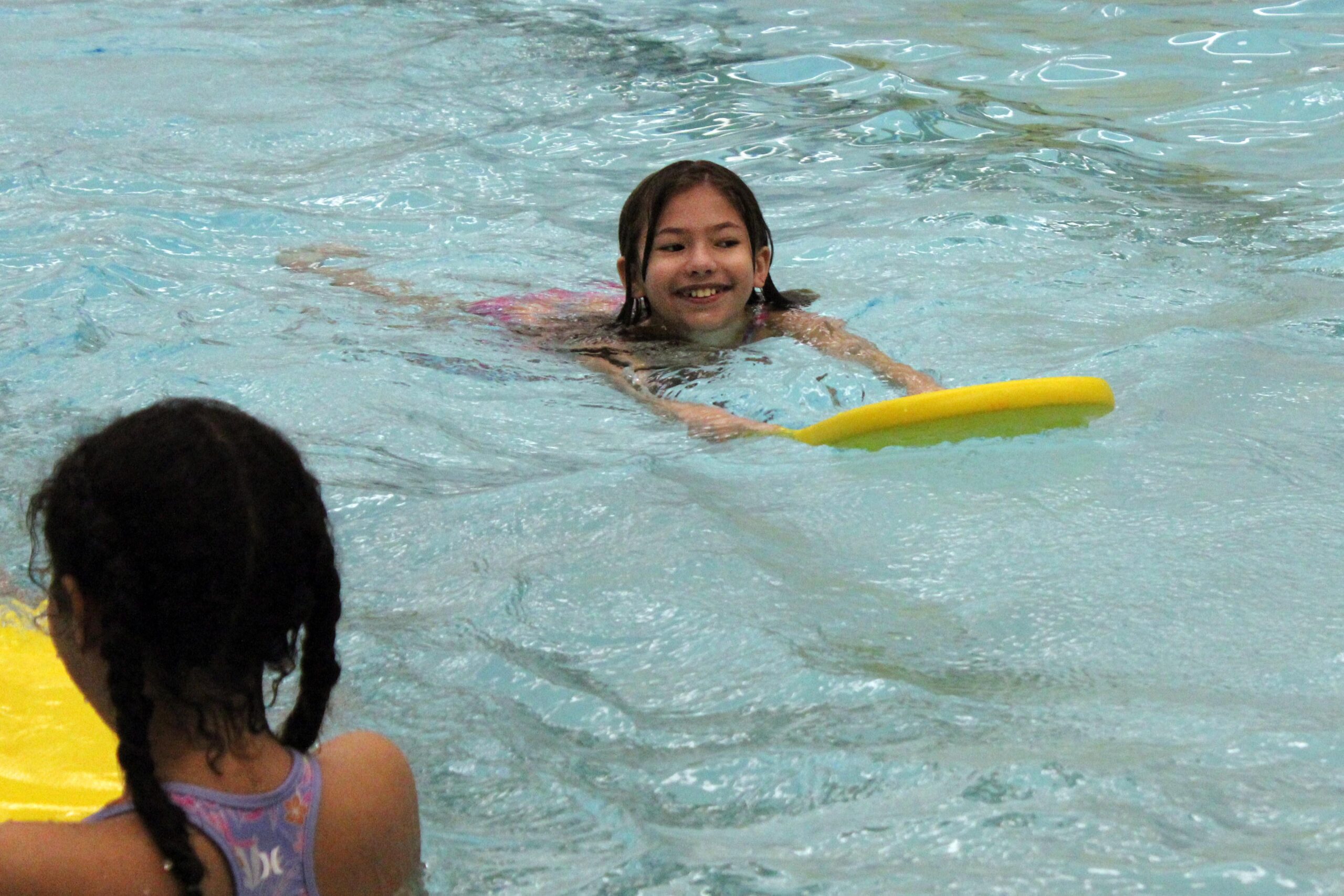 girl swimming with kickboard
