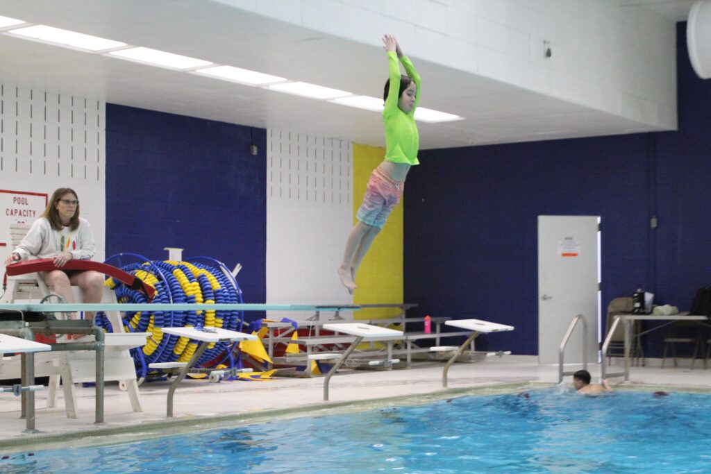 boy jumping off diving board
