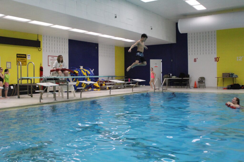 boy jumping off diving board