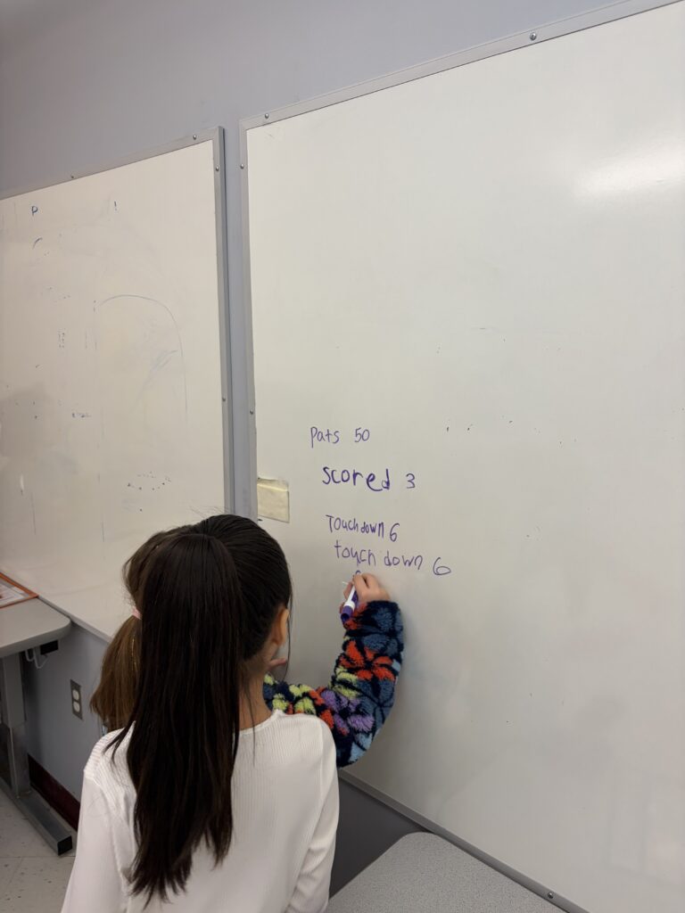 girl writing on dry erase board