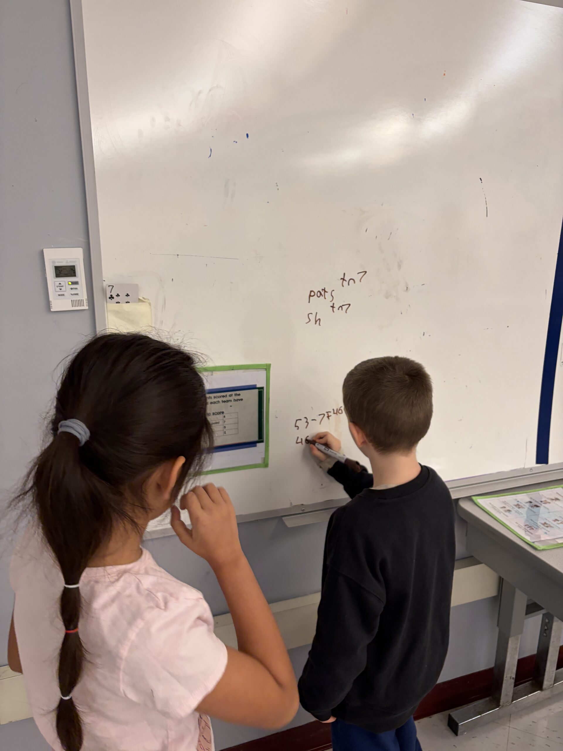 boy writing on dry erase board