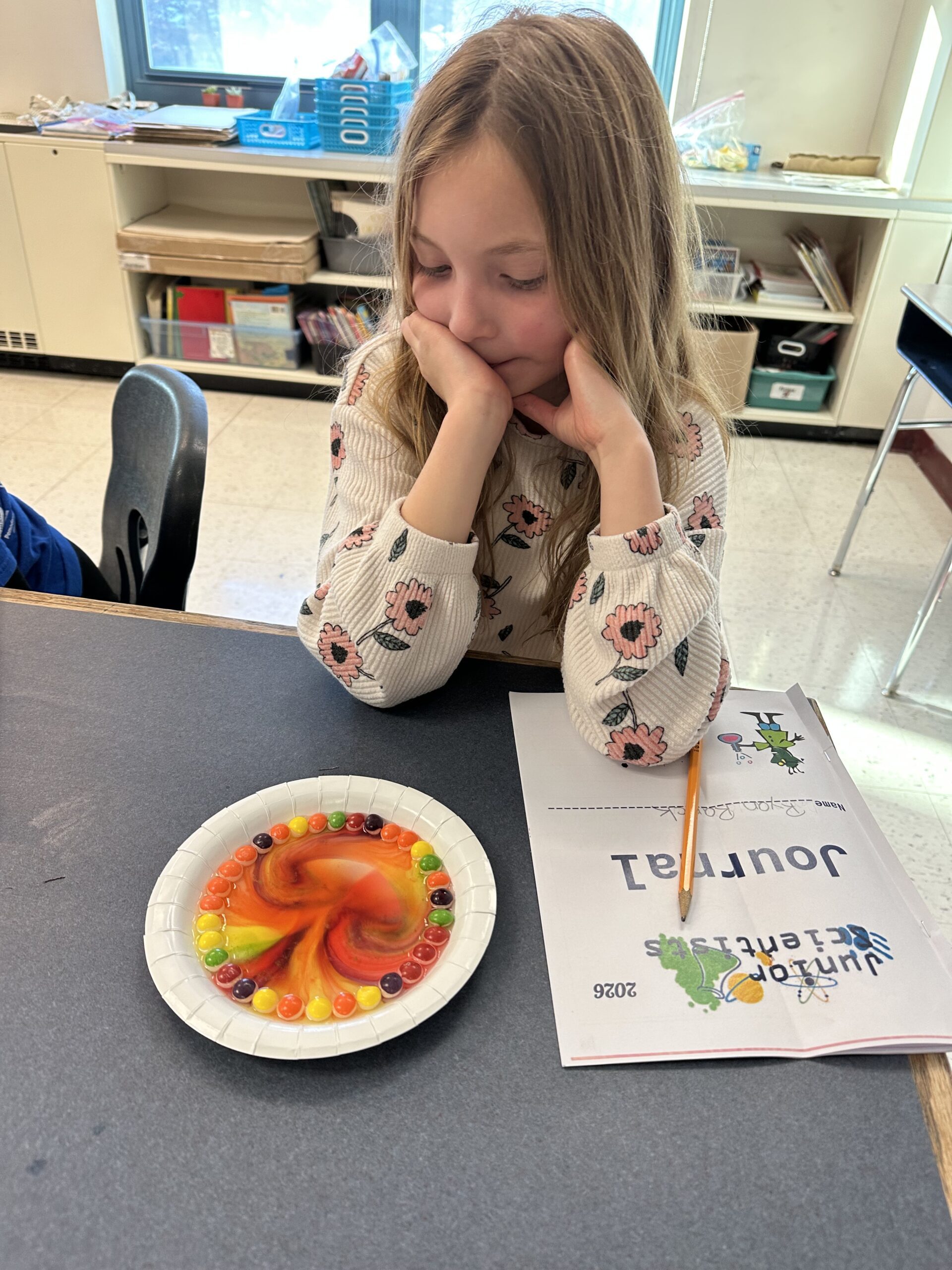 girl watching Skittles colors mix together