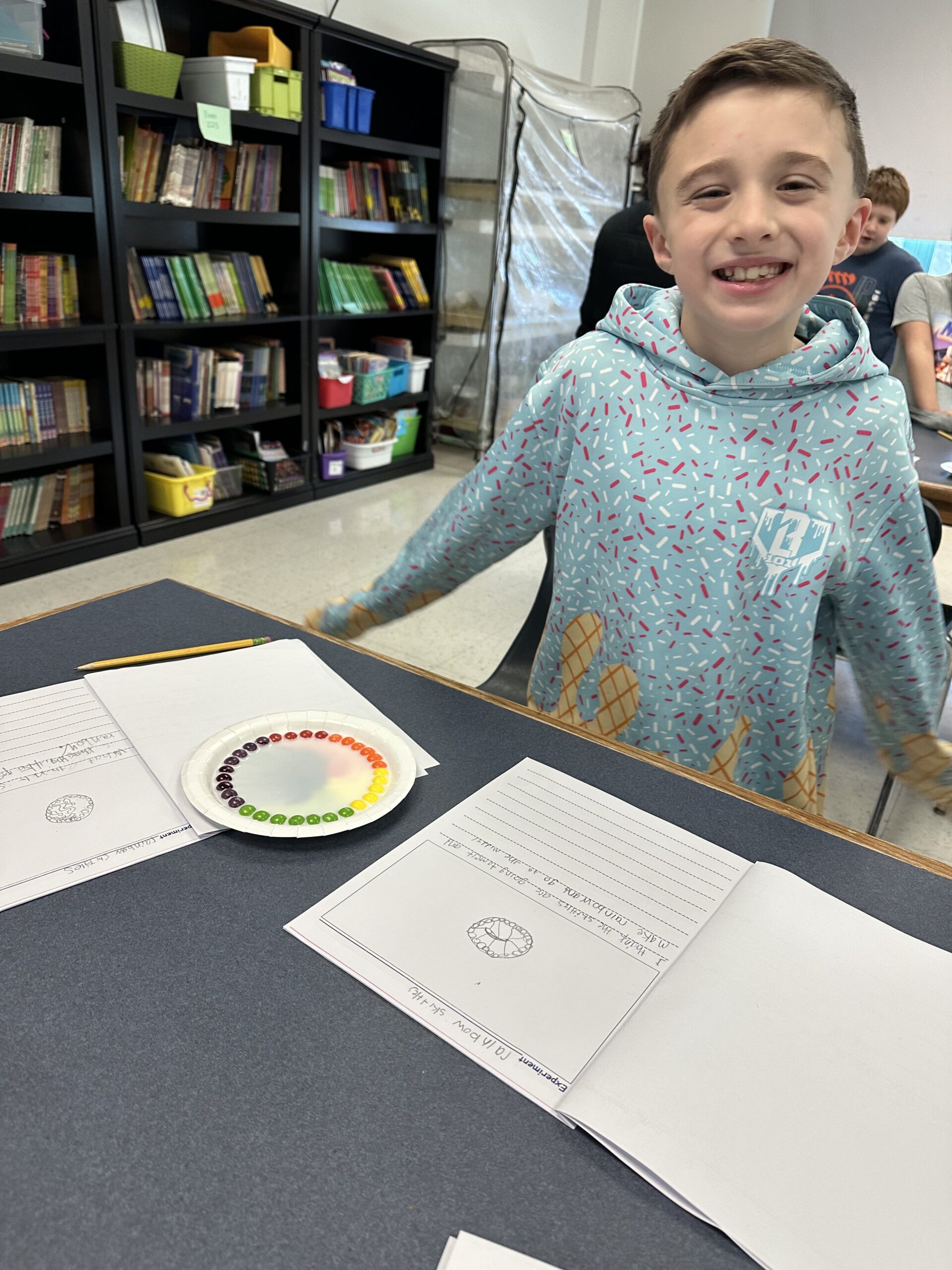 boyl watching Skittles colors mix together