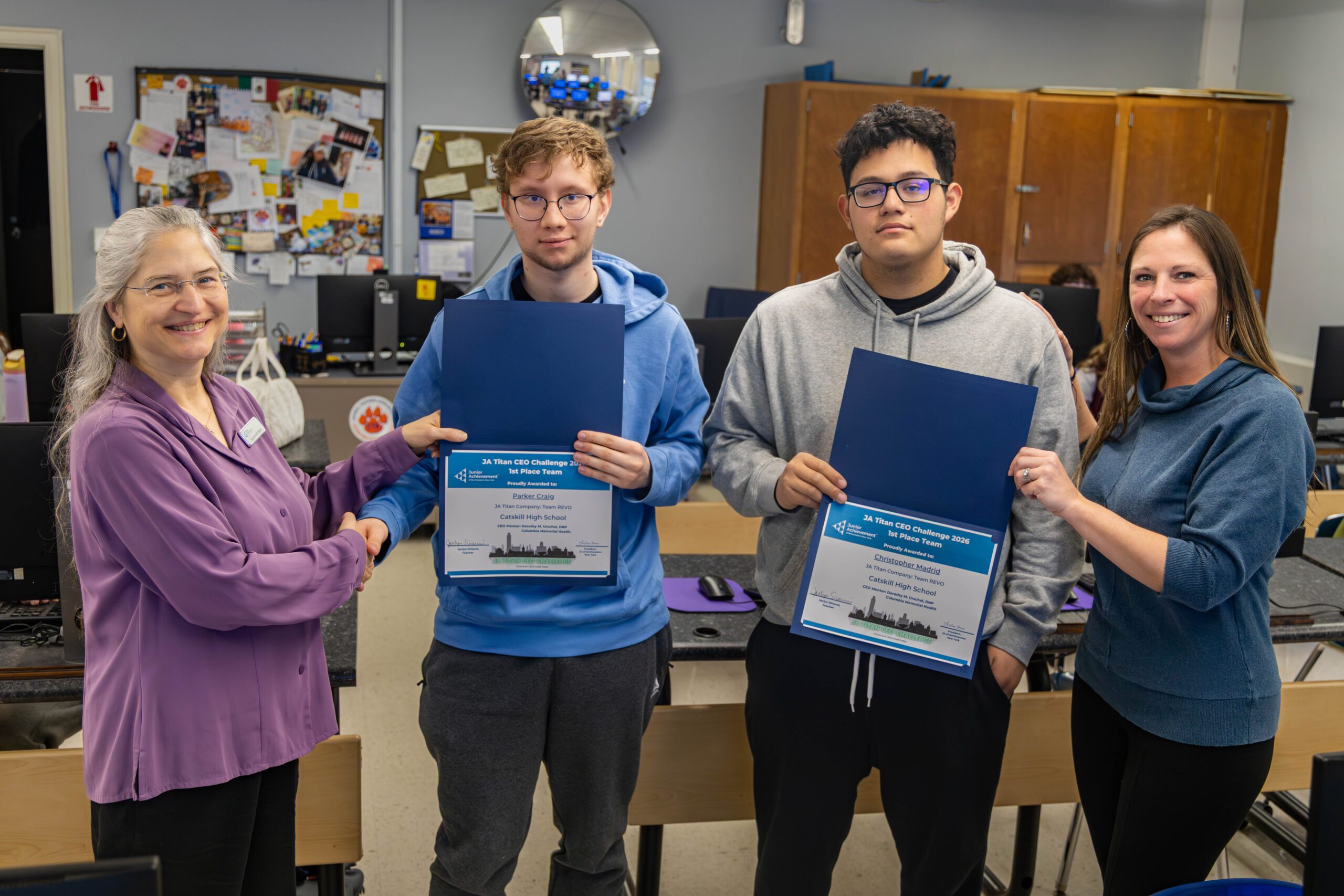 two women handing award certificates to two young men