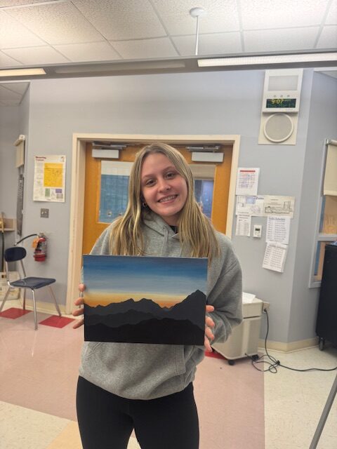 girl holding sunset landscape painting