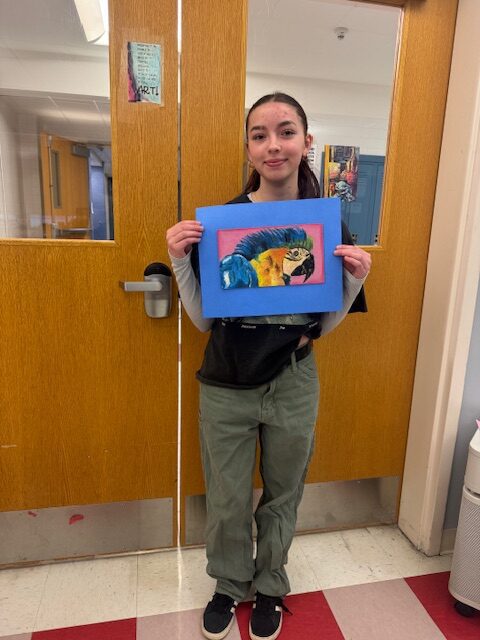 girl holding drawing of parrot