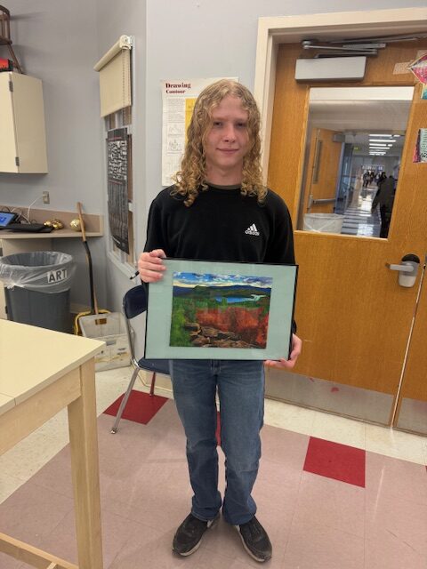 boy holding landscape painting