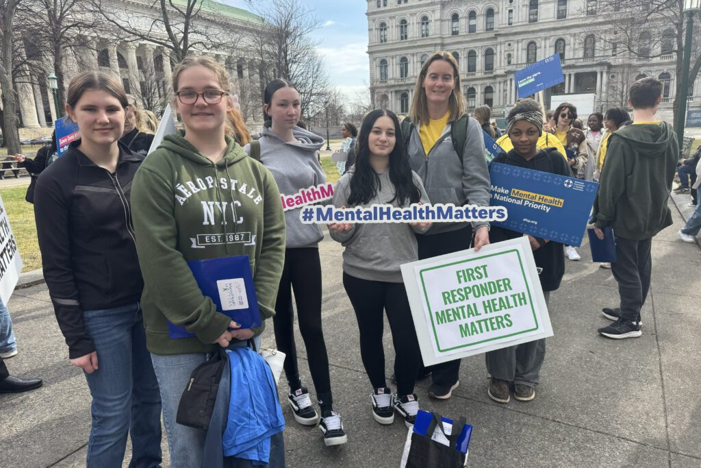 students and woman holding rallying for mental health outside NYS Capitol