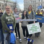students and woman holding rallying for mental health outside NYS Capitol