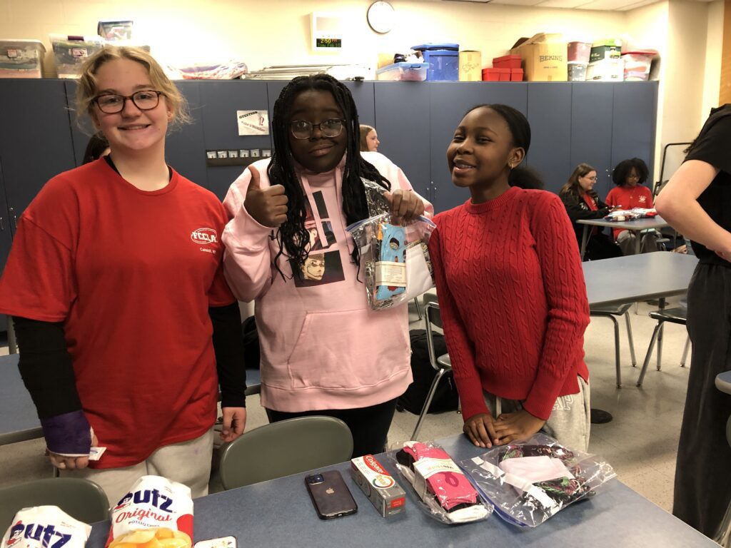 three girls assembling care packages