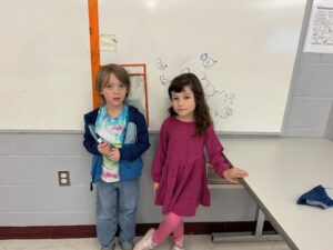 two students doing math problem on whiteboard