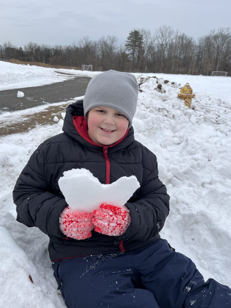 boy holding chunk of snow.