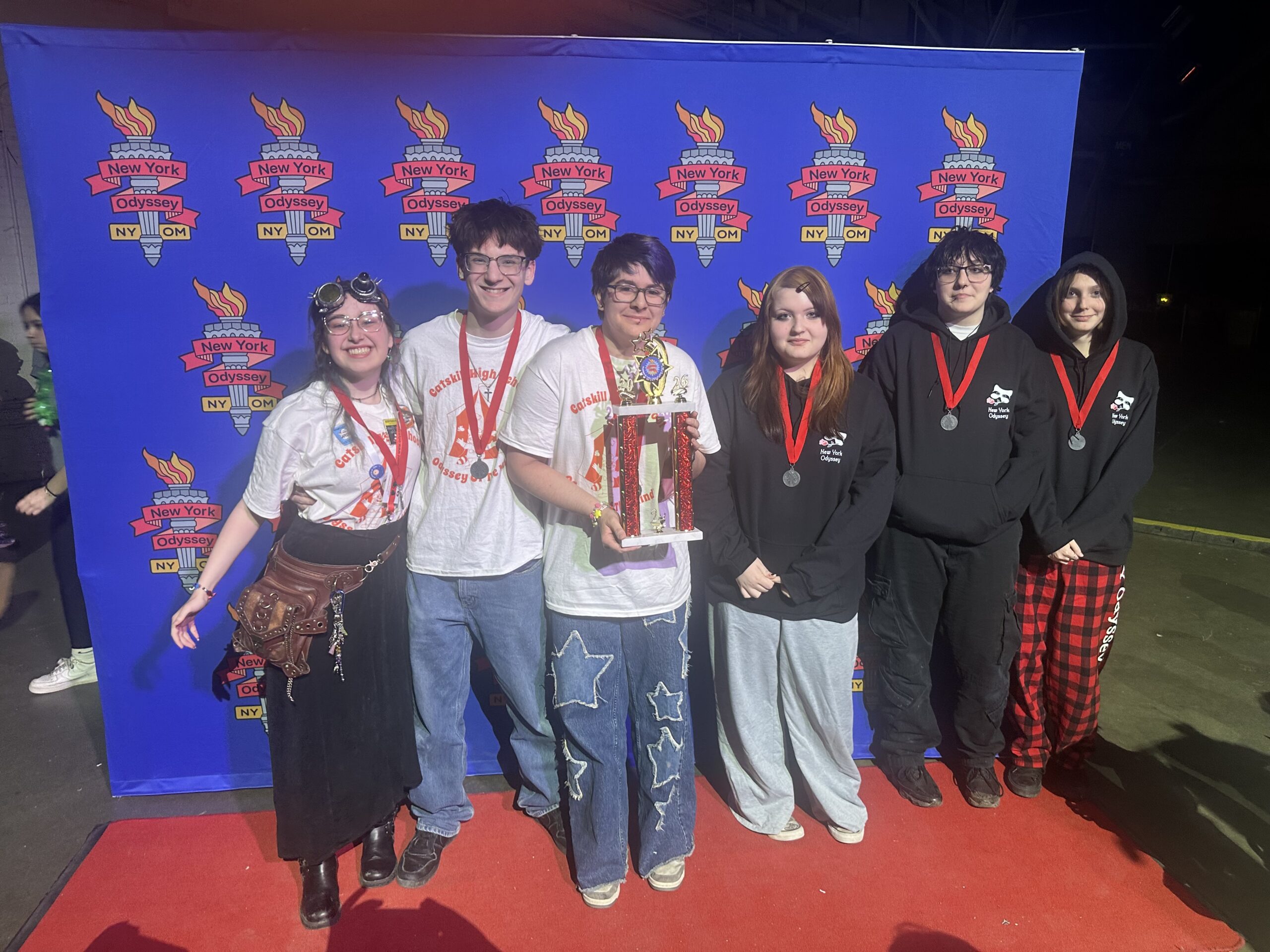 Catskill High School Odyssey of the Mind team poses with trophy and medals at NYS competition.
