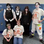 students wea4ing clown makeup pose for team photo