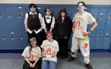 students wea4ing clown makeup pose for team photo