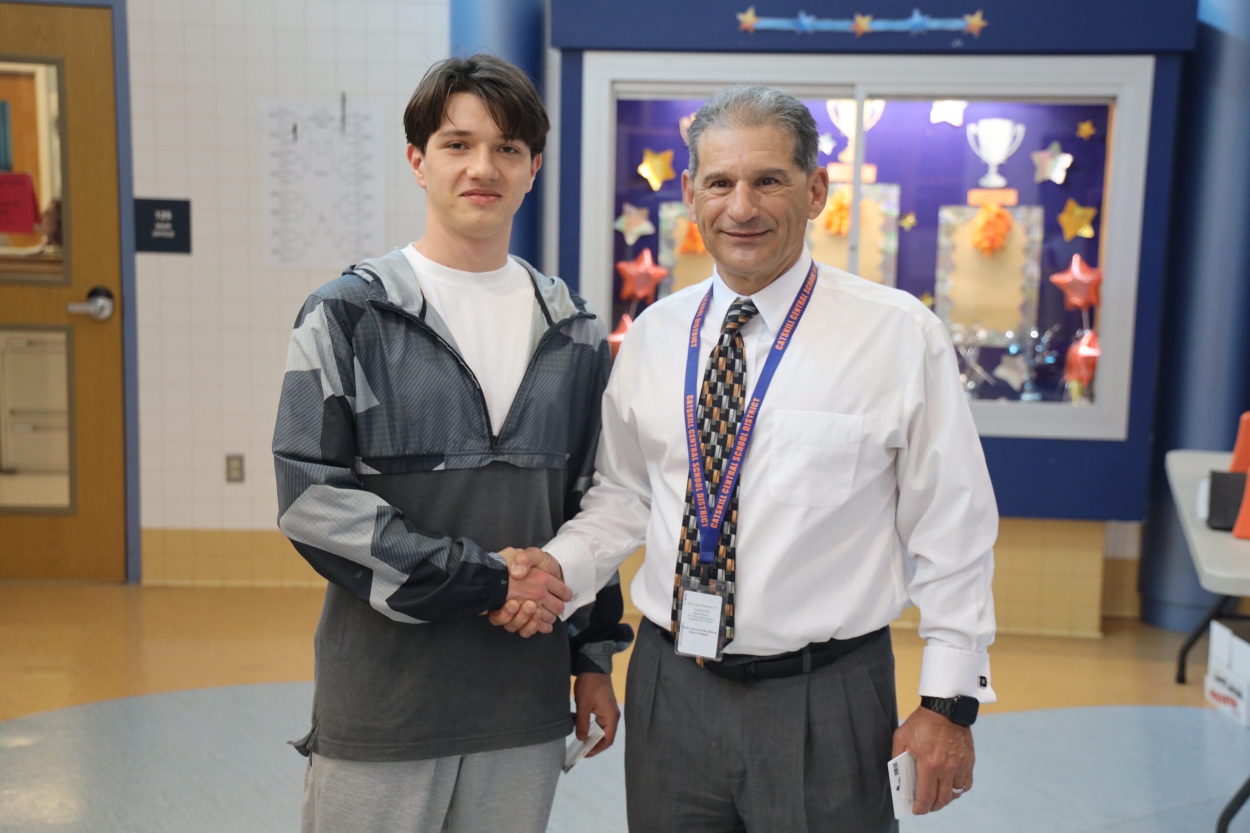 man shaking teenage boy's hand