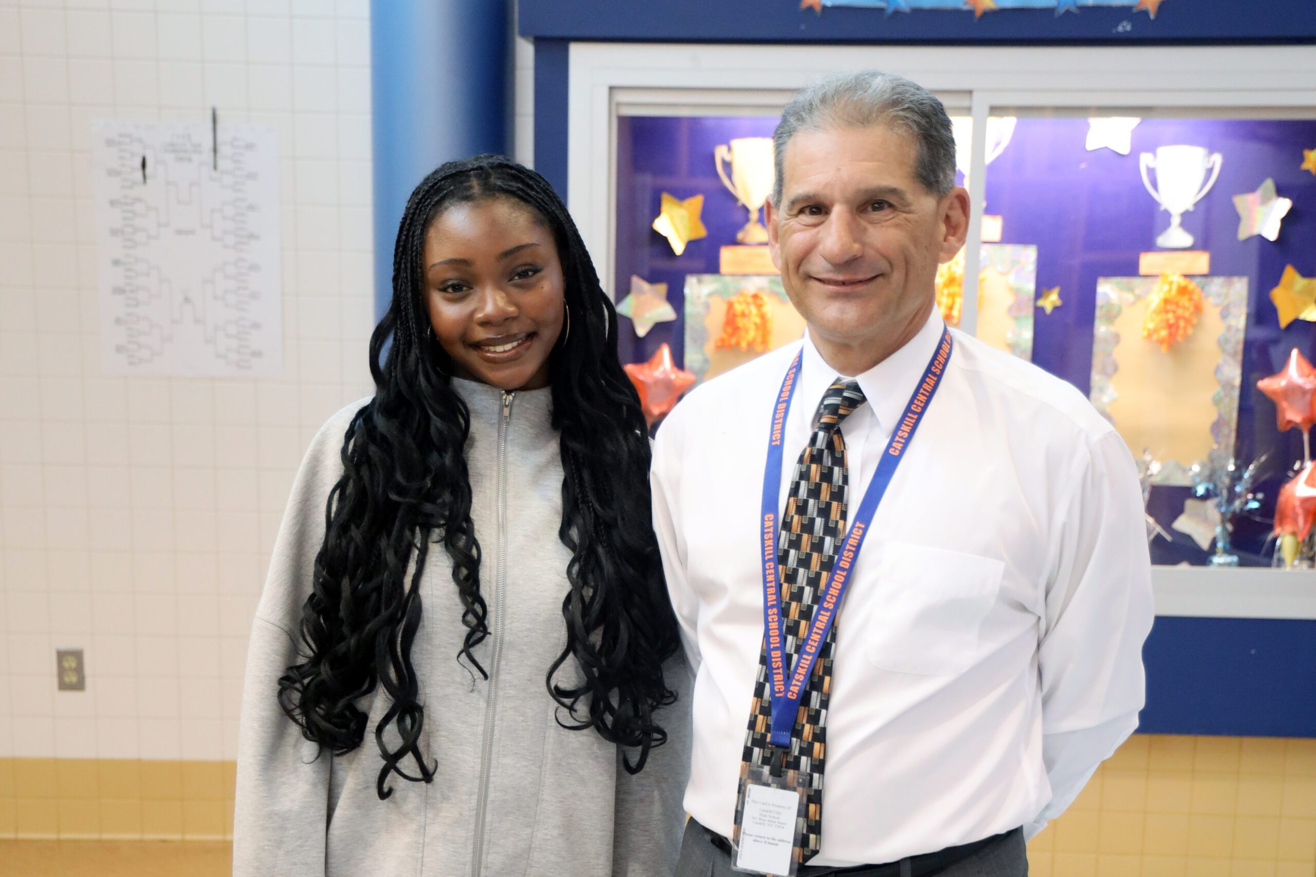 smiling man standing next to smiling teenage girl