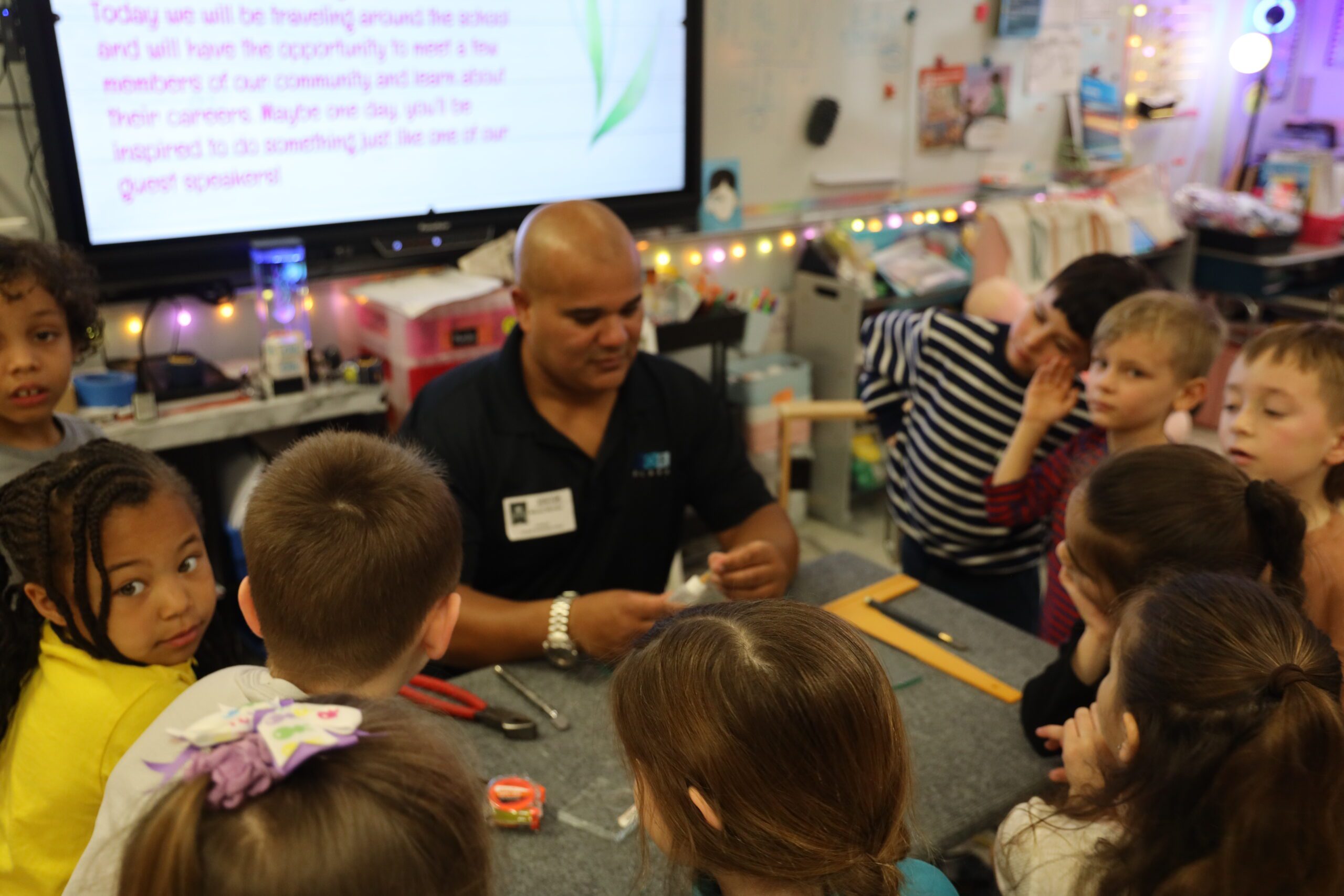 man giving job presentation to students gathered around a table