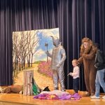 student on stage with cast of The Wizard of Oz