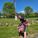 boy holding miniature American flags