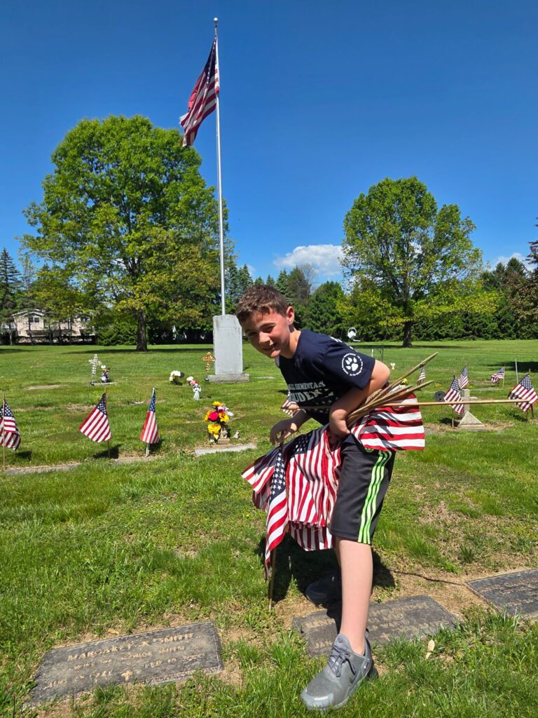 boy holding miniature American flags