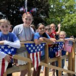 students ride on patriotic parade float