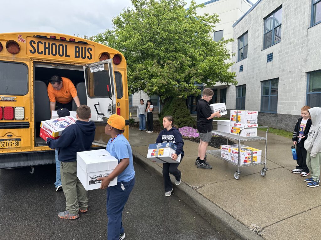 students loading boxes onto school bus