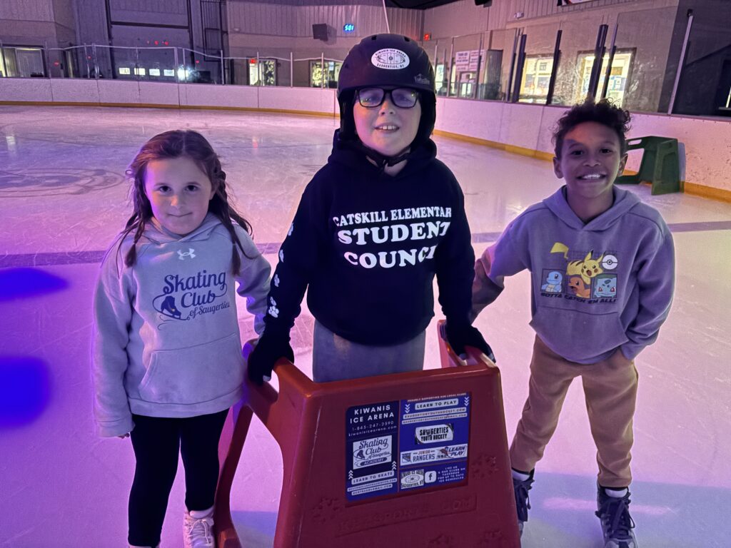 students skating on ice using skate helpers