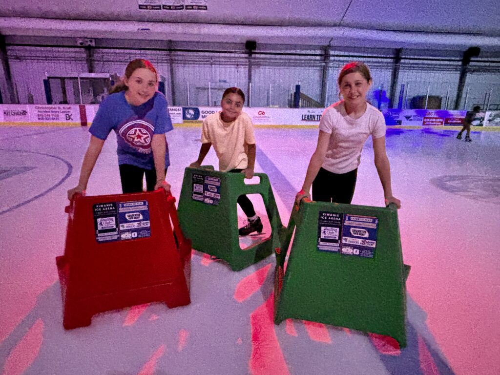 students skating on ice using skate helpers