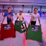 students skating on ice using skate helpers
