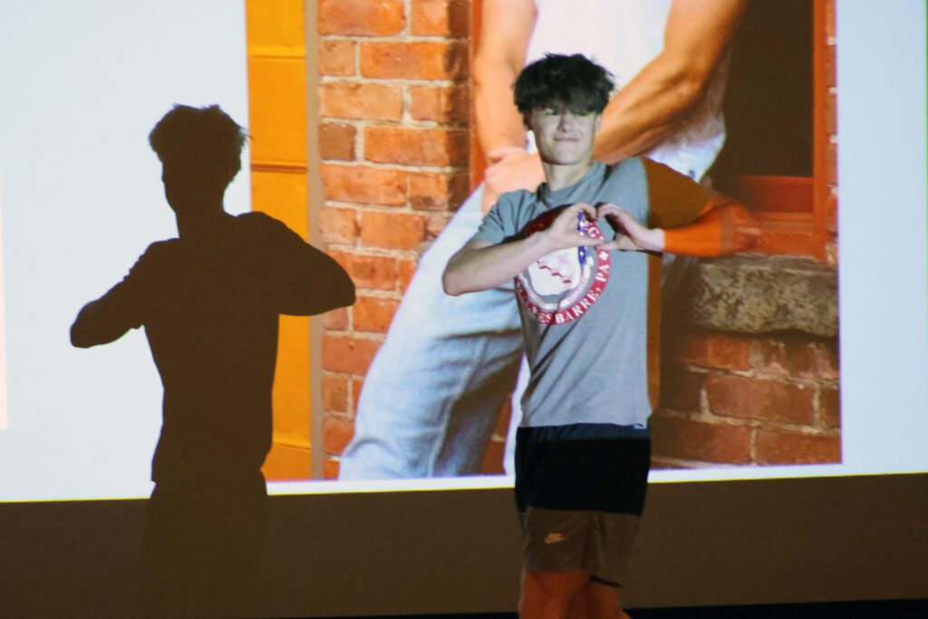 young man making heart sign on stage