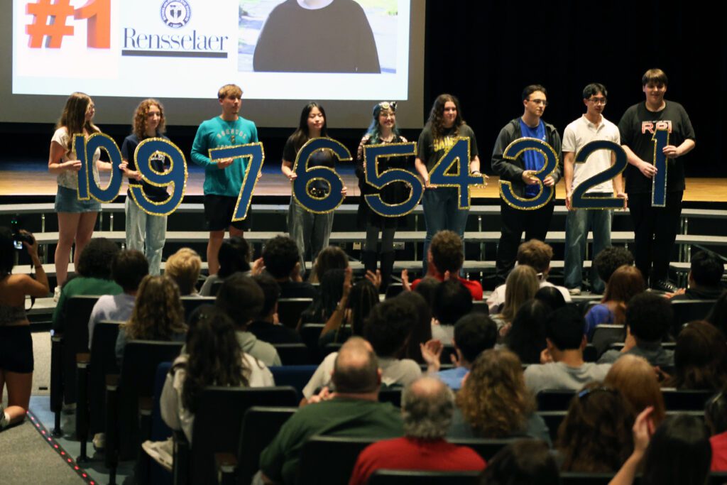 students on risers holding numbers one through ten