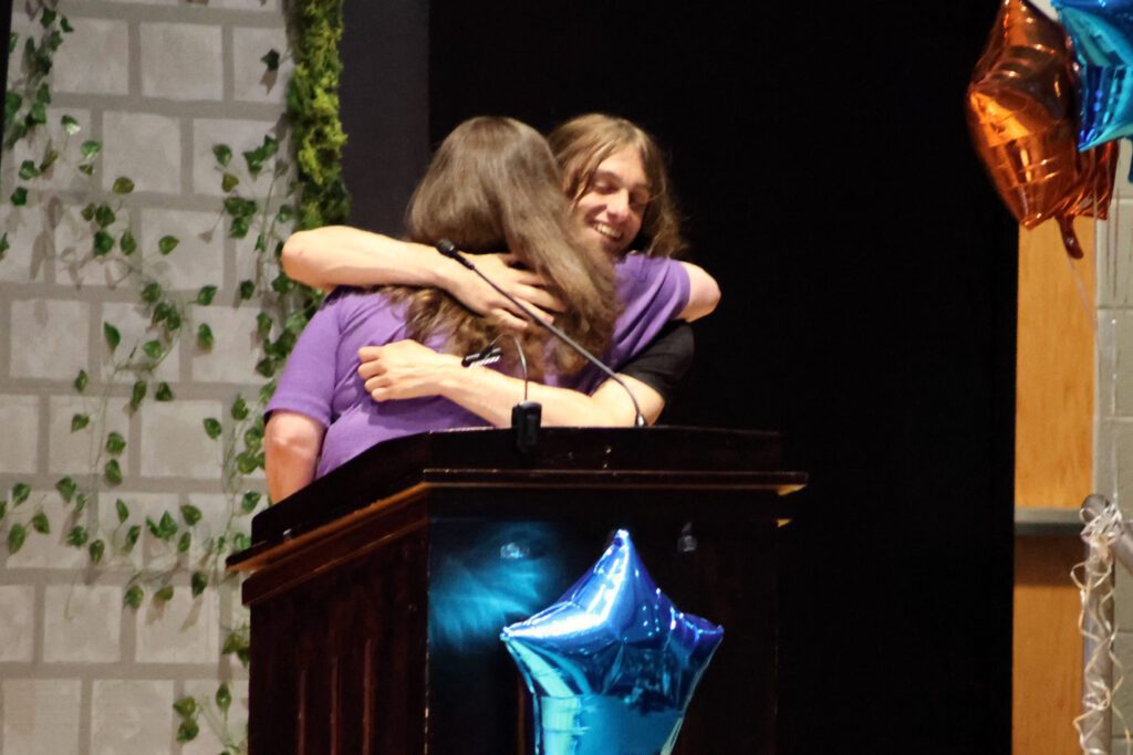 student giving woman a hug