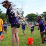 girl tossibng water on girl